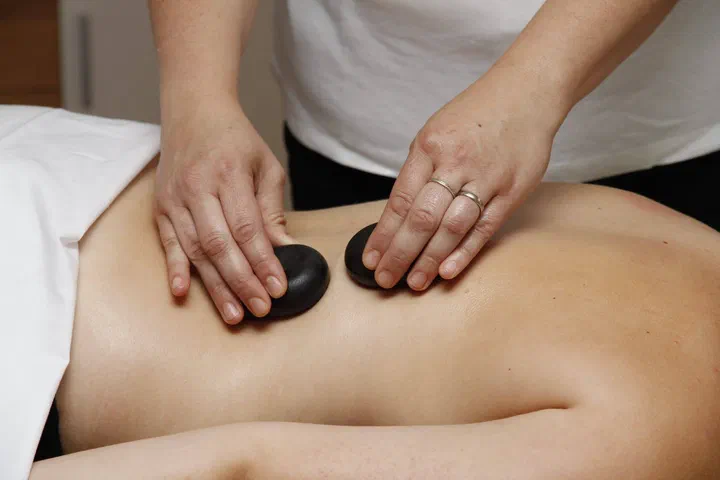 Hot-stone-Massage: erhitzte Basaltsteine auf dem Rücken